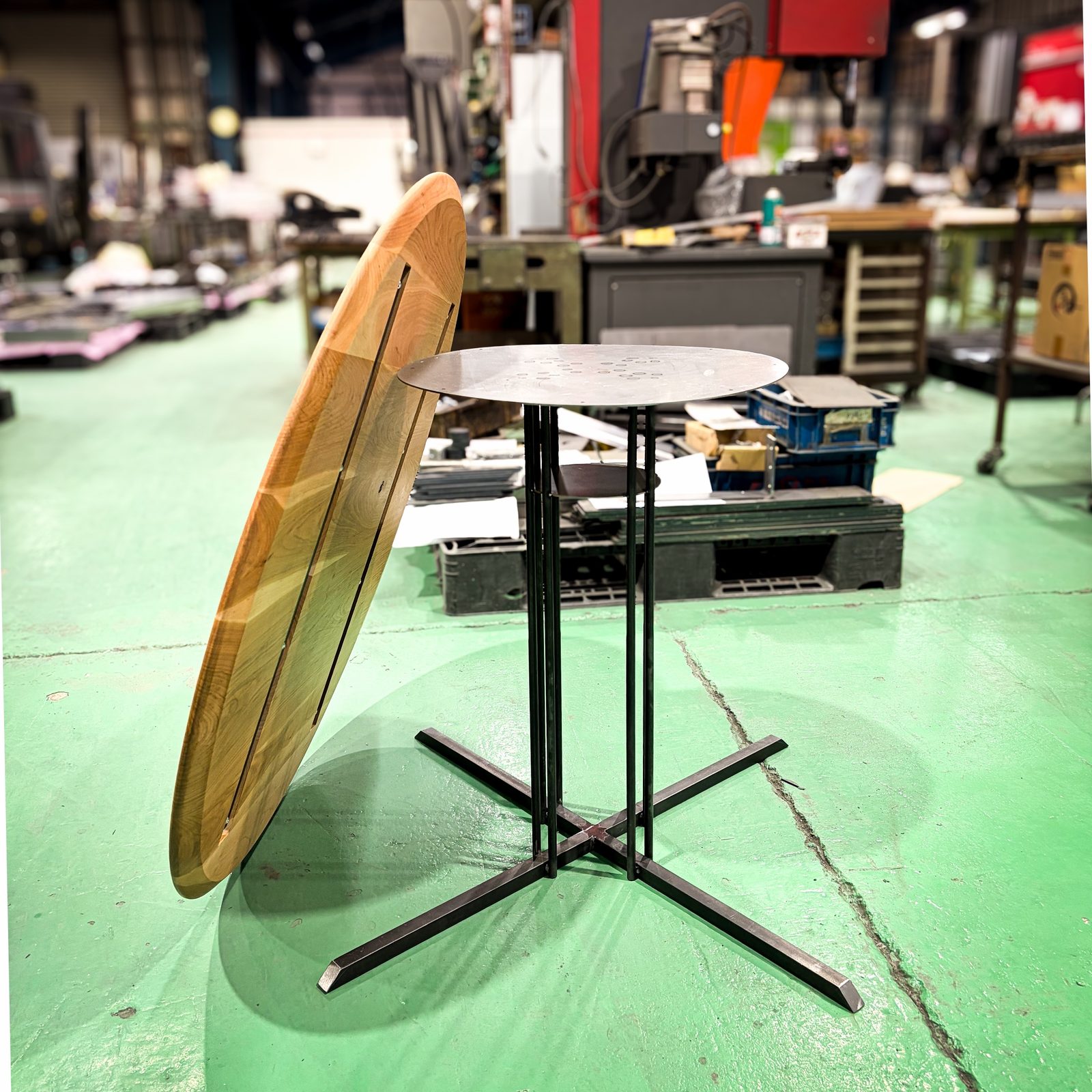 The leg structure, with the underside of the top leaning beside it